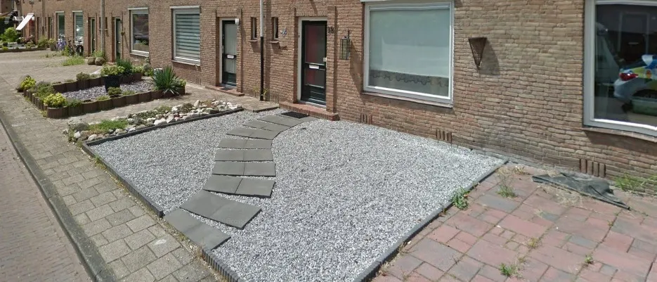 Voortuin nu: wit grind met stapstenen